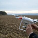 Técnico especializado ajustando un dron para tareas de agricultura de precisión en un campo de cultivo