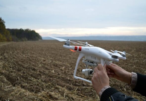 Técnico especializado ajustando un dron para tareas de agricultura de precisión en un campo de cultivo